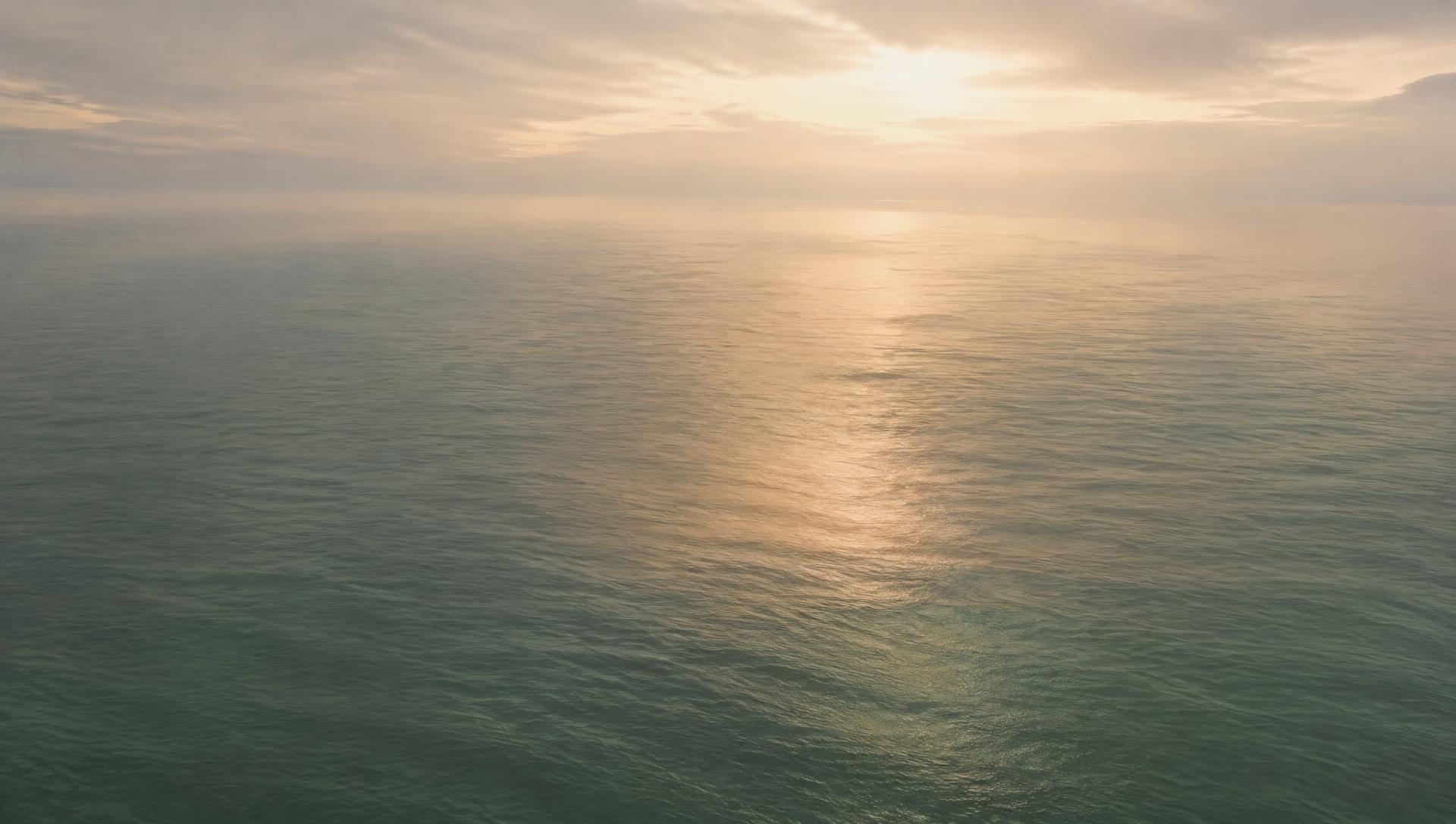 Calm ocean surface at dawn under soft light